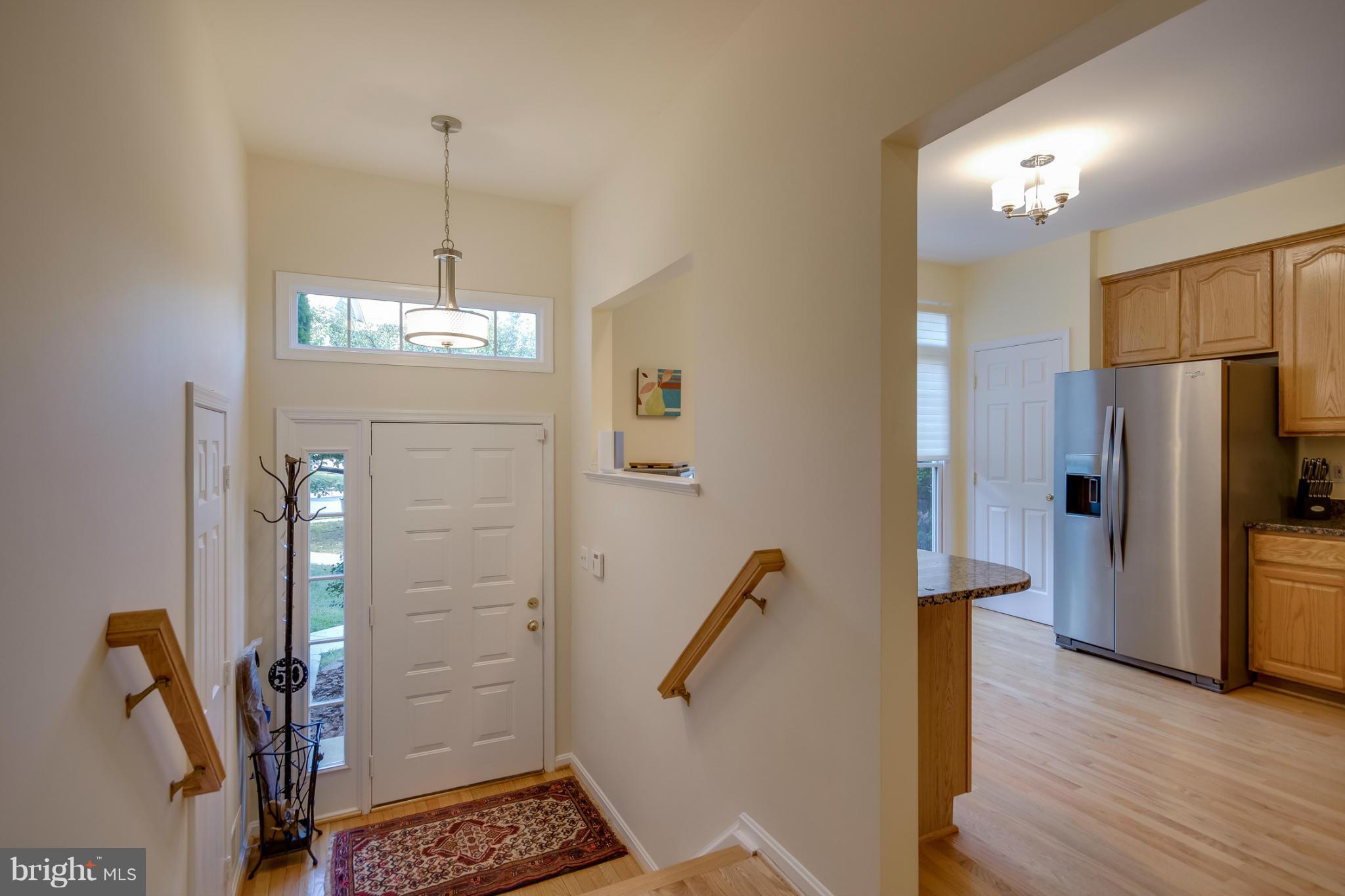 1279 Weatherstone Court Reston, VA 20194 - Photo 2 of 28 a view of a hallway with wooden floor and chandelier