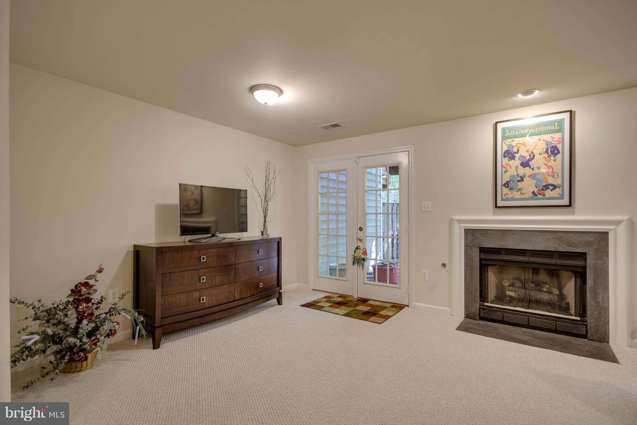 1279 Weatherstone Court Reston, VA 20194 - Photo 22 of 28 a living room with furniture a flat screen tv and a fireplace