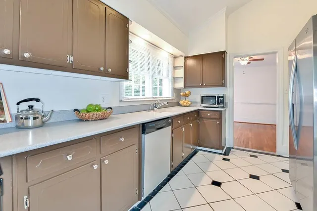 a kitchen with stainless steel appliances a sink cabinets and a window