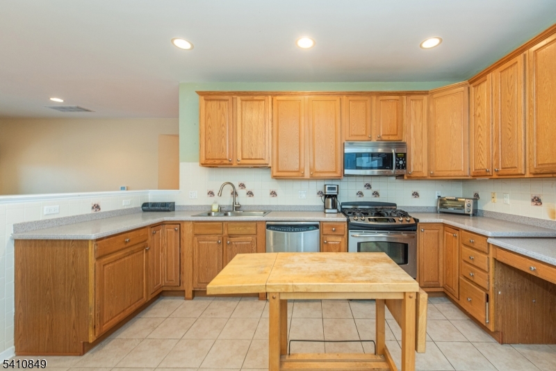 10323 Warren's Way Wanaque, NJ 07465 - Photo 10 of 30 a kitchen with stainless steel appliances granite countertop wooden cabinets a sink and a stove