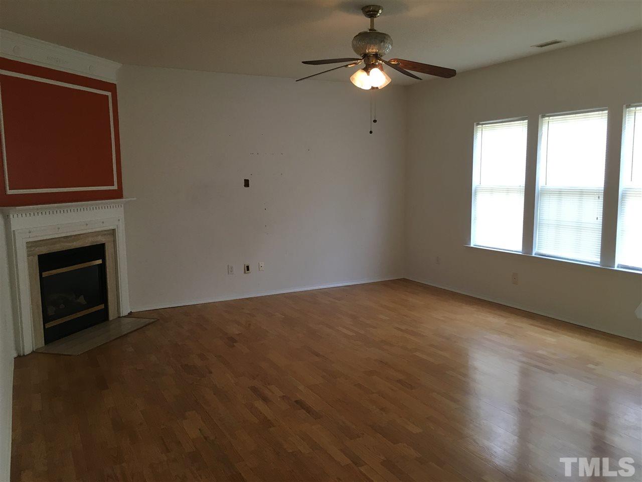 4841 Heatherfield Way Raleigh, NC 27604 - Photo 3 of 23 a view of an empty room with a fireplace and a window