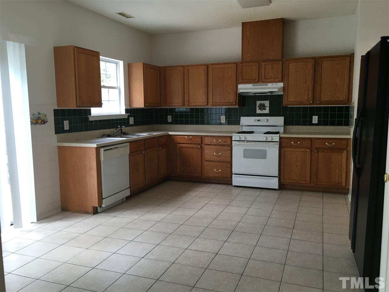 4841 Heatherfield Way Raleigh, NC 27604 - Photo 7 of 23 a kitchen with a sink window and stainless steel appliances