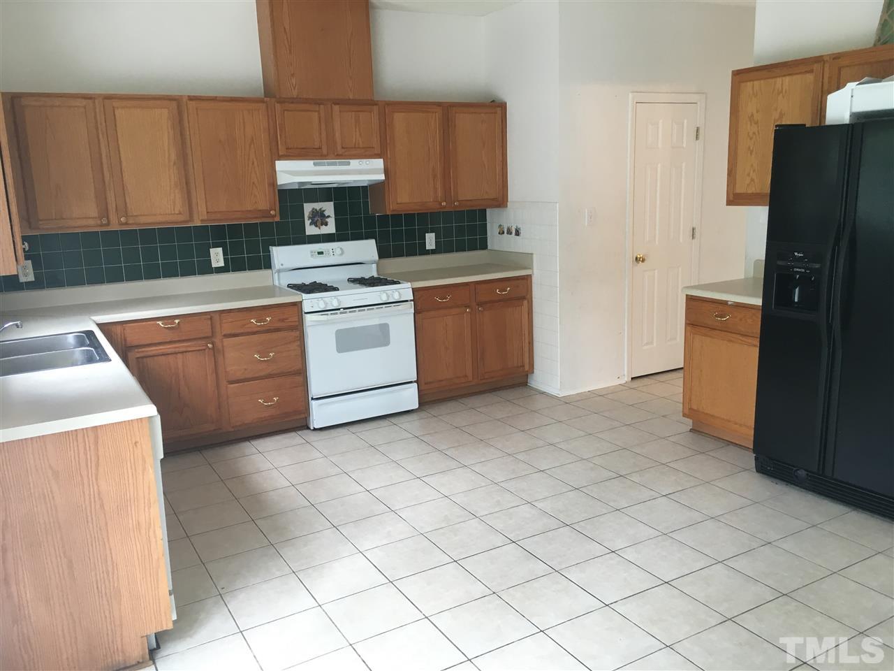 4841 Heatherfield Way Raleigh, NC 27604 - Photo 8 of 23 a kitchen with a stove refrigerator and cabinets
