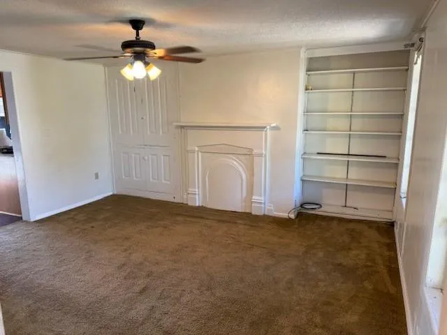 an empty room with a fireplace and chandelier