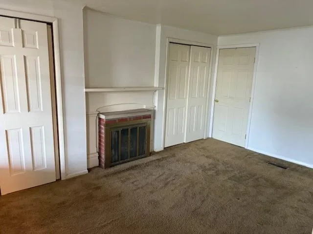 an empty room with wooden floor and window