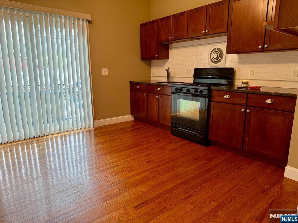 59 Laurel Avenue, Unit RIGHT SIDE Kearny, NJ 07032 - Photo 4 of 16 a kitchen with wooden floors and wooden cabinets
