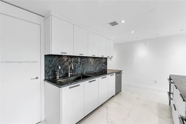 a kitchen with granite countertop a sink and a stove top oven