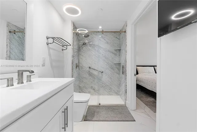 a bathroom with a sink a toilet and shower