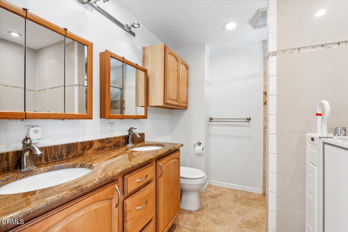 111 Bottlebrush Circle Oxnard, CA 93030 - Photo 25 of 44 a bathroom with a granite countertop sink a toilet and a shower
