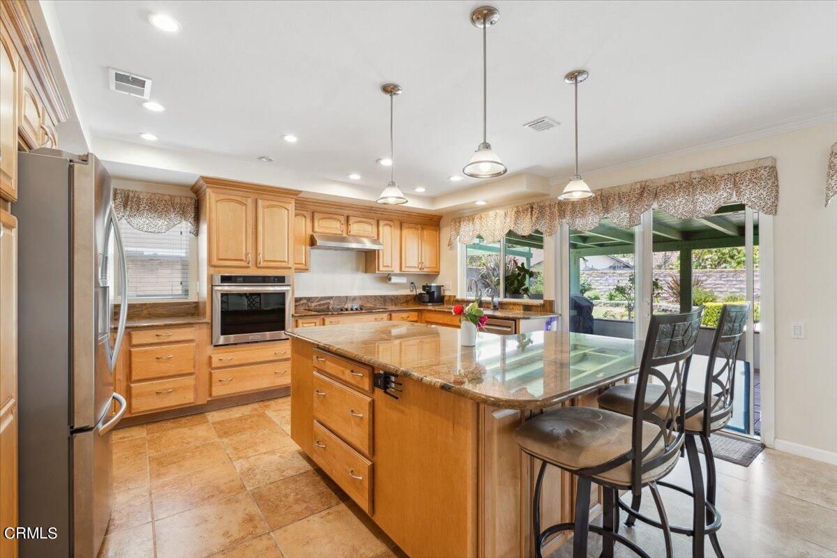 111 Bottlebrush Circle Oxnard, CA 93030 - Photo 8 of 44 a kitchen with stainless steel appliances granite countertop a stove top oven a refrigerator and kitchen island