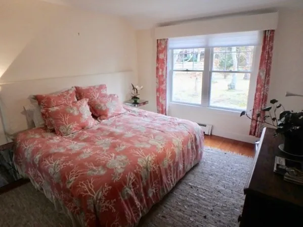 a large bed sitting in a bedroom next to a window