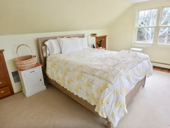 a large bed sitting in a bedroom next to a window with lamp