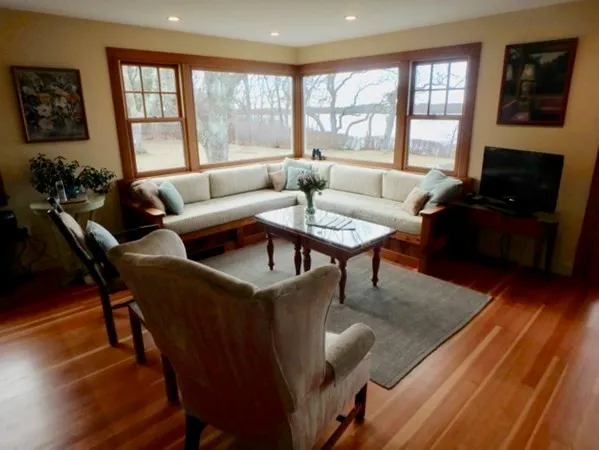 a living room with furniture wooden floor and a floor to ceiling window