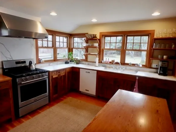 a kitchen with stainless steel appliances granite countertop a stove a sink and a microwave