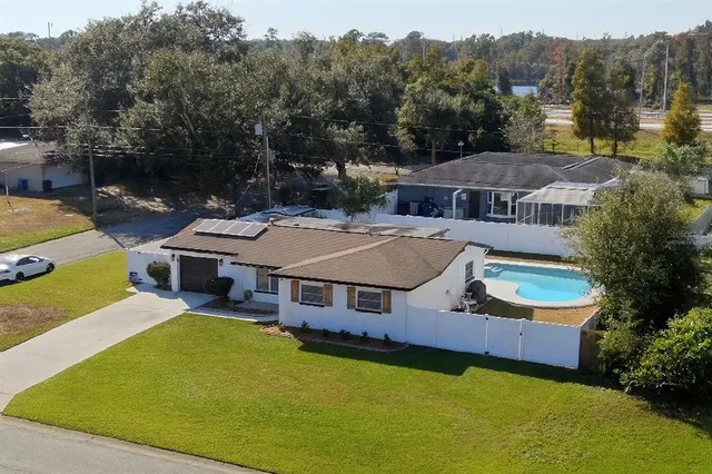 an aerial view of a house with swimming pool and a yard