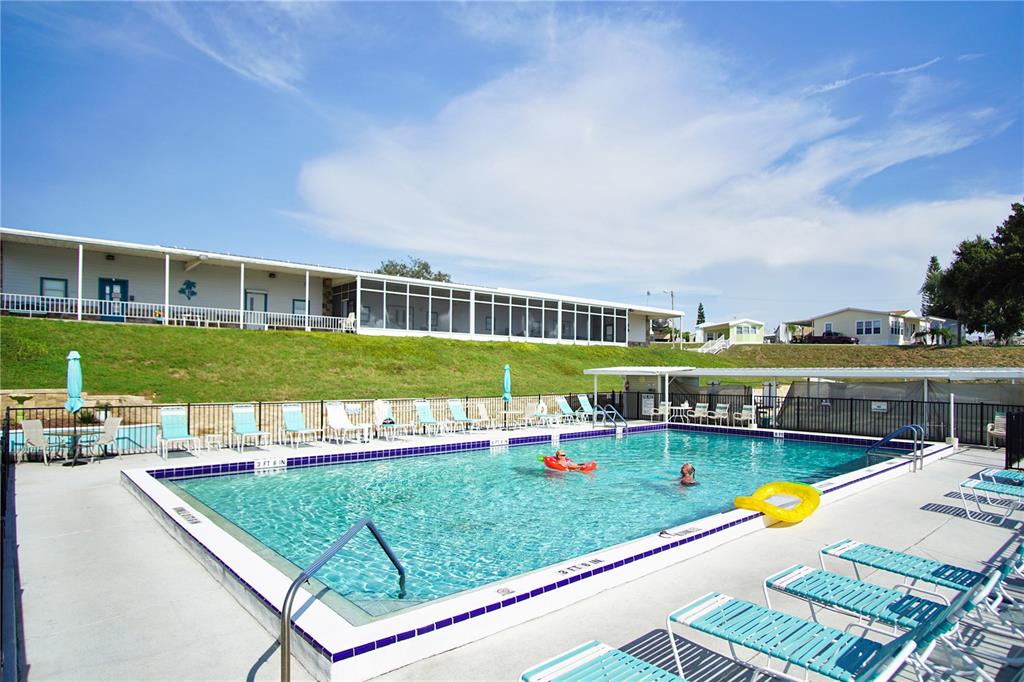 251 Patterson Road, Unit C13 Haines City, FL 33844 - Photo 20 of 28 a view of a swimming pool with lawn chairs and a fire pit