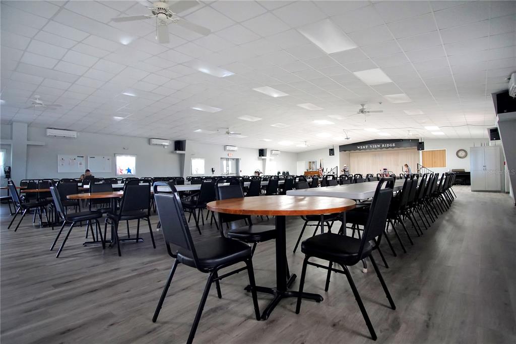 251 Patterson Road, Unit C13 Haines City, FL 33844 - Photo 27 of 28 a dining hall with stainless steel appliances a table chairs and a bookshelf