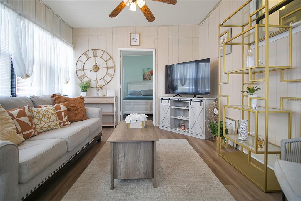 251 Patterson Road, Unit C13 Haines City, FL 33844 - Photo 5 of 28 a living room with furniture a flat screen tv and a floor to ceiling window