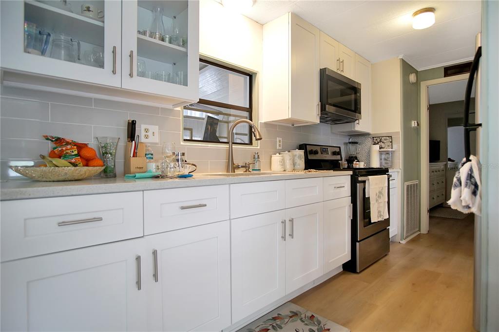 251 Patterson Road, Unit C13 Haines City, FL 33844 - Photo 6 of 28 a kitchen with white cabinets and appliances