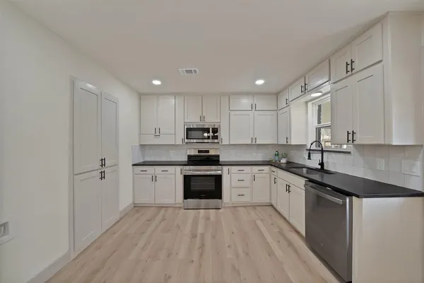 a kitchen with a sink stainless steel appliances and cabinets