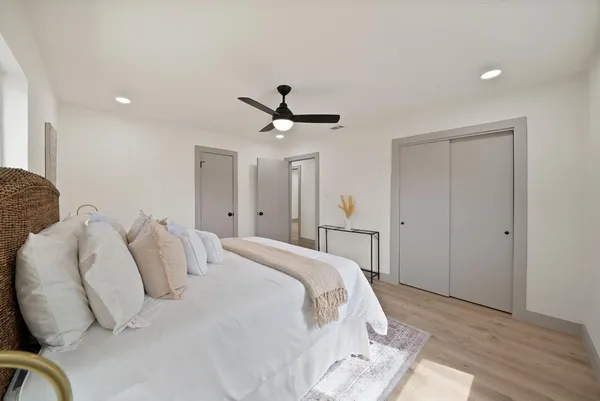 a bed room with a bed and a ceiling fan