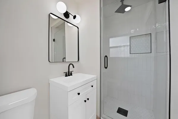 a bathroom with a sink toilet and mirror