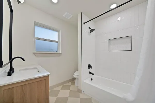 a bathroom with a tub sink and mirror
