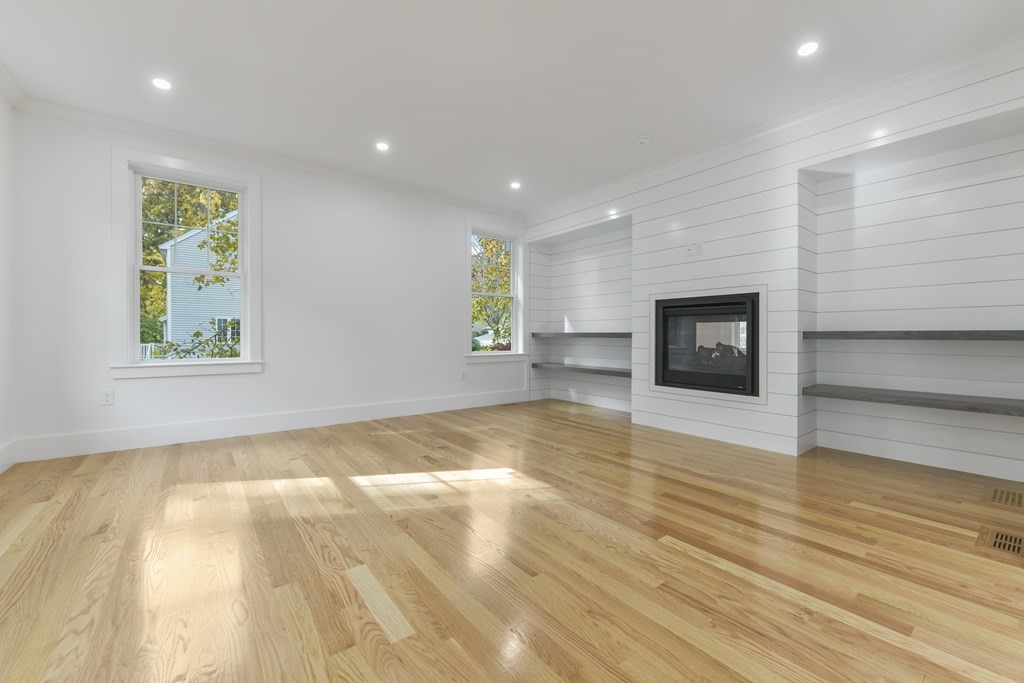30 Oscars Way Dedham, MA 02026 - Photo 13 of 39 a view of empty room with wooden floor and fireplace