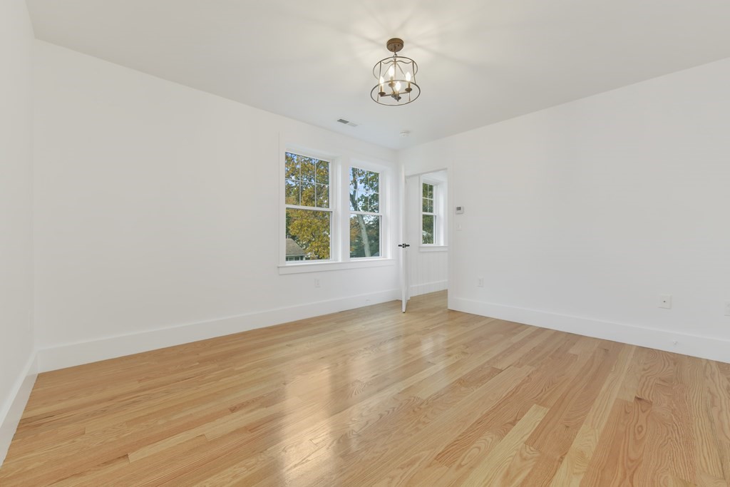 30 Oscars Way Dedham, MA 02026 - Photo 21 of 39 a view of an empty room with a window and wooden floor