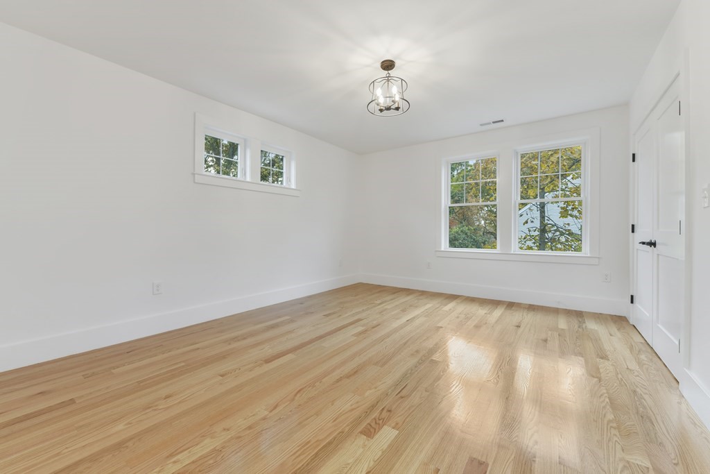 30 Oscars Way Dedham, MA 02026 - Photo 27 of 39 a view of an empty room with wooden floor and a window