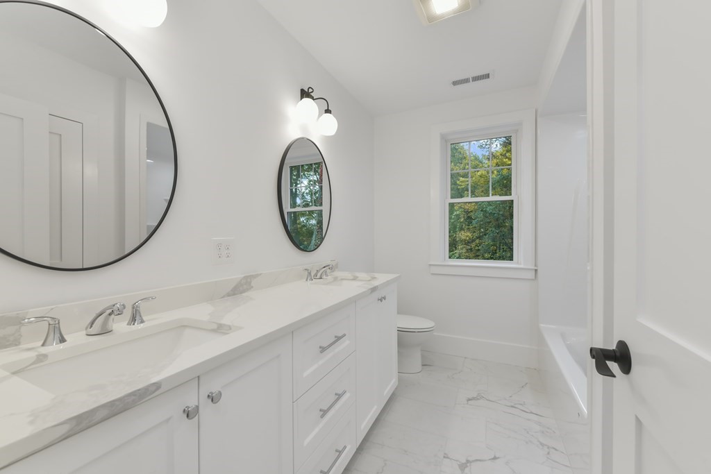 30 Oscars Way Dedham, MA 02026 - Photo 30 of 39 a bathroom with a double vanity sink and a mirror