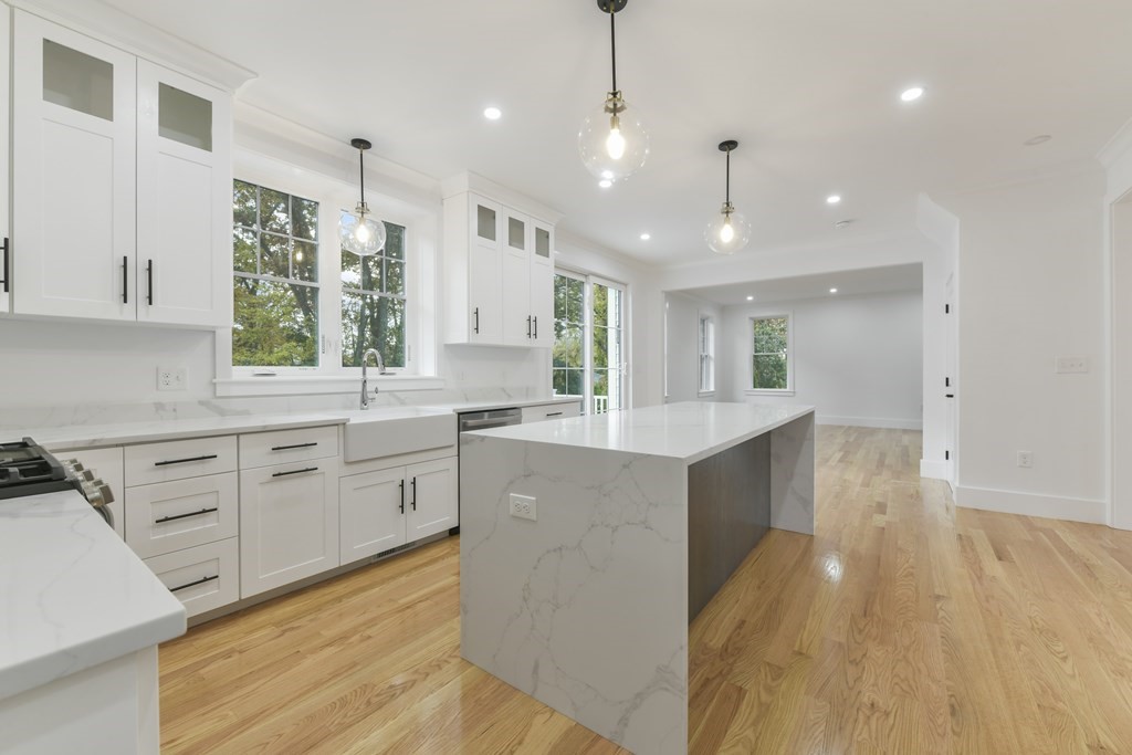30 Oscars Way Dedham, MA 02026 - Photo 4 of 39 a large kitchen with cabinets wooden floor and stainless steel appliances