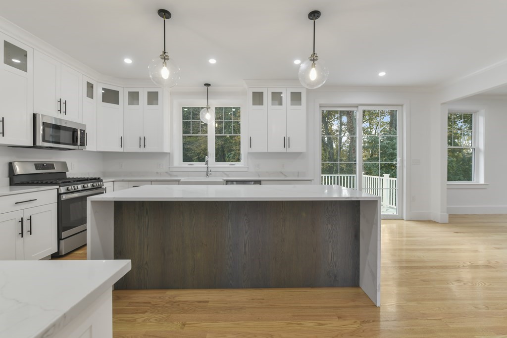 30 Oscars Way Dedham, MA 02026 - Photo 5 of 39 a kitchen with granite countertop a stove a sink and a refrigerator