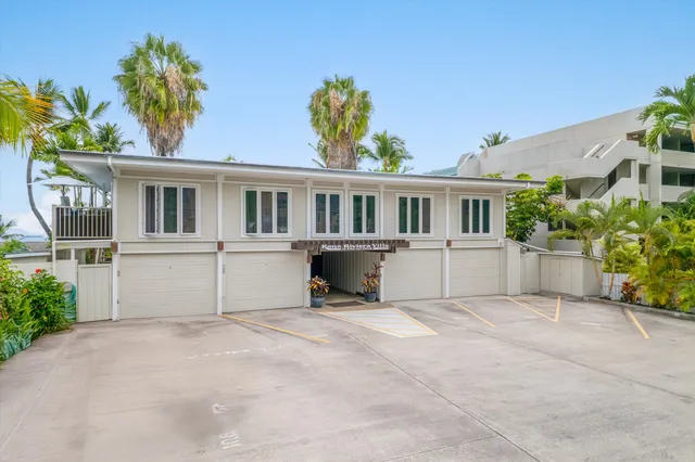 a front view of a house with a garden and yard