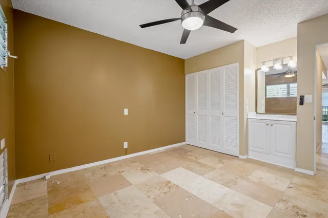 a view of an empty room with a chandelier fan