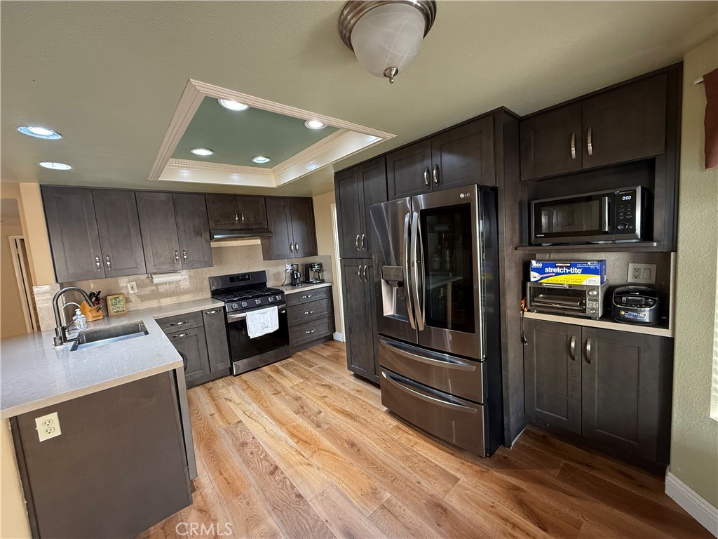 21182 Tennyson Road Moreno Valley, CA 92557 - Photo 12 of 36 a kitchen with stainless steel appliances granite countertop a refrigerator a stove top oven a sink and dishwasher