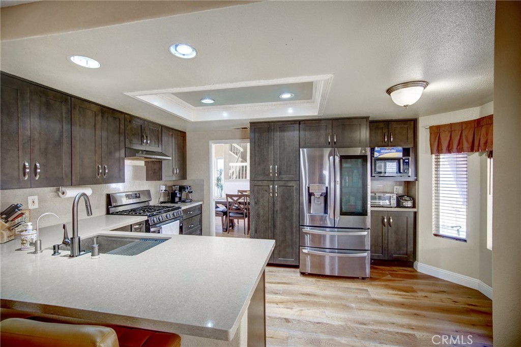 21182 Tennyson Road Moreno Valley, CA 92557 - Photo 13 of 36 a kitchen with stainless steel appliances granite countertop a refrigerator sink and cabinets