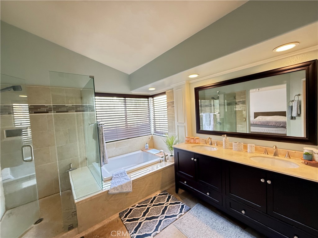 21182 Tennyson Road Moreno Valley, CA 92557 - Photo 17 of 36 a bathroom with a double vanity sink a mirror and a bathtub