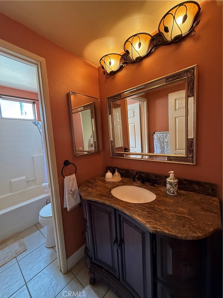 21182 Tennyson Road Moreno Valley, CA 92557 - Photo 28 of 36 a bathroom with a granite countertop sink a mirror and a bathtub