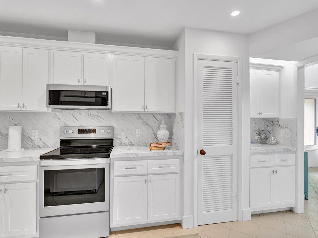 1155 Reef Road, Unit B2 Vero Beach, FL 32963 - Photo 8 of 32 a kitchen with white cabinets and stainless steel appliances