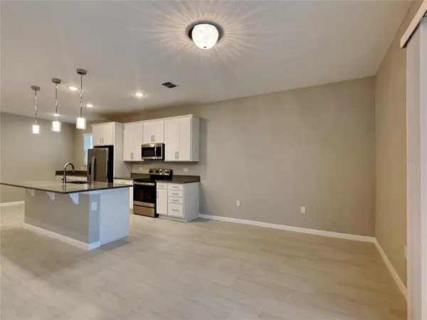 a view of kitchen with refrigerator sink and stove