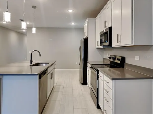 a kitchen with stainless steel appliances granite countertop a sink a stove and a refrigerator