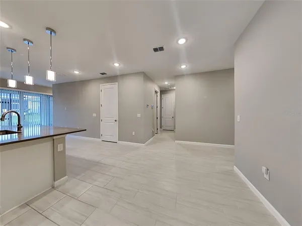 a view of a kitchen with kitchen island a sink stainless steel appliances and cabinets