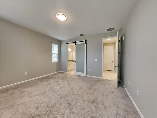 an empty room with windows and bathroom view