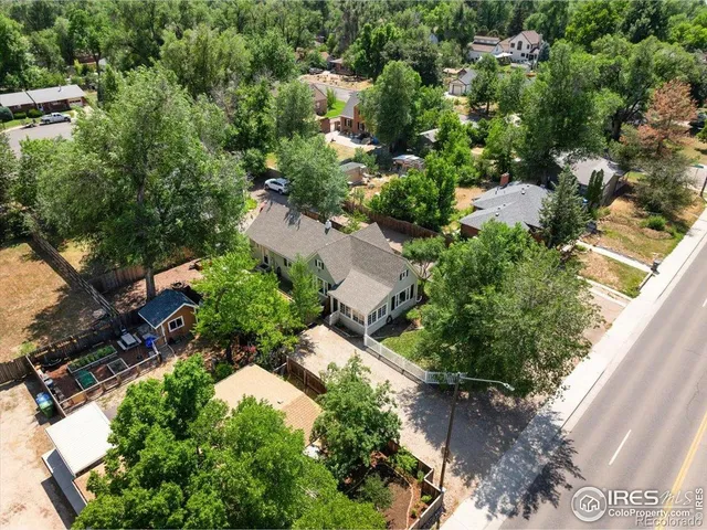 an aerial view of residential house with outdoor space and trees all around