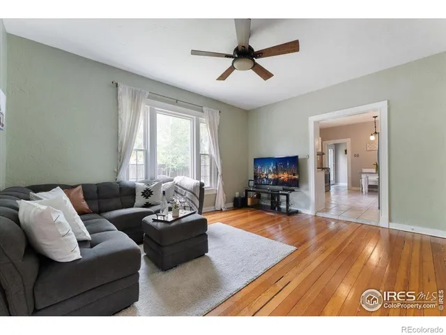 a living room with furniture and a flat screen tv with wooden floor