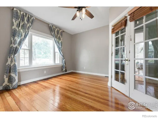 a view of an empty room with a window and wooden floor