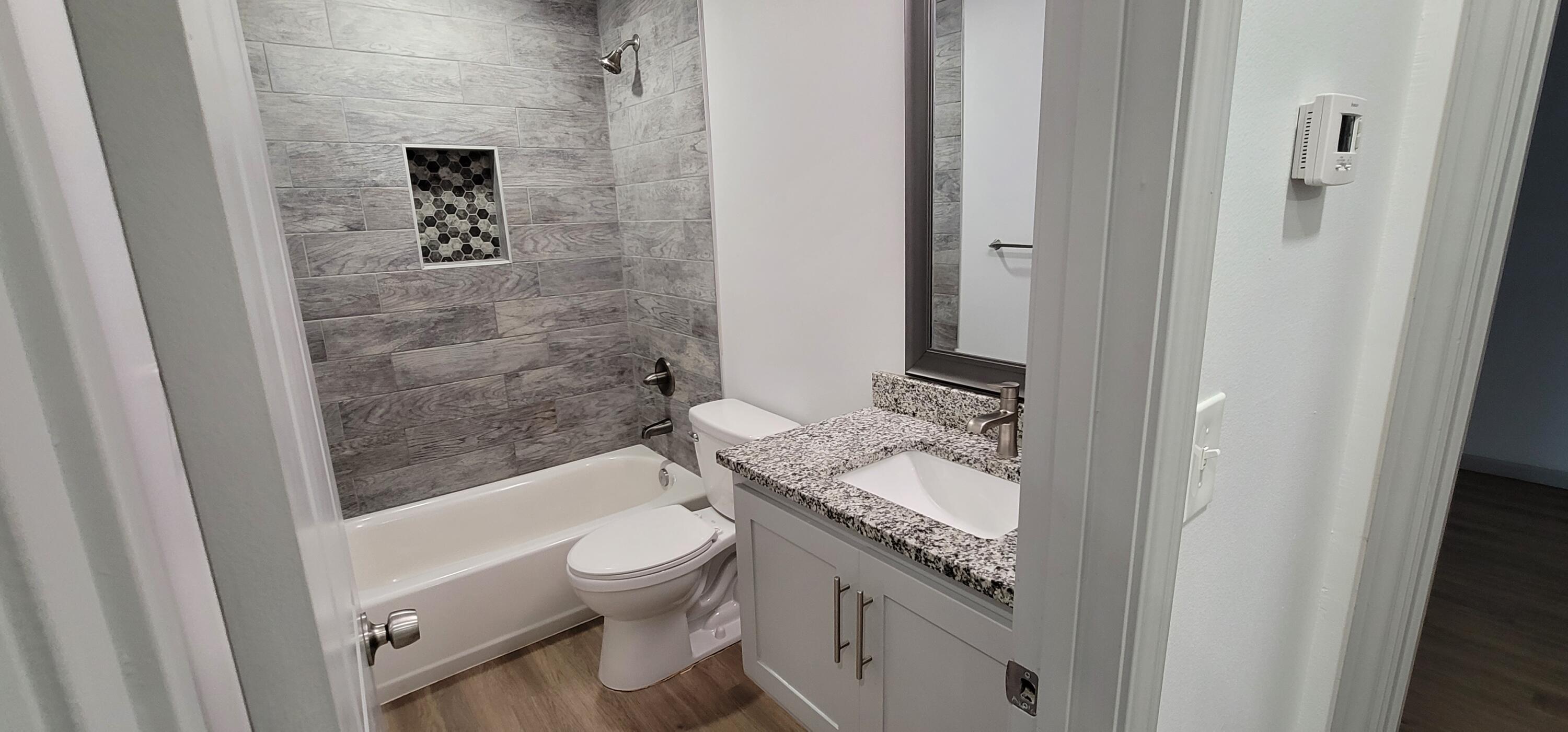 2110 88th Street Lubbock, TX 79423 - Photo 18 of 22 a bathroom with a granite countertop sink toilet and shower