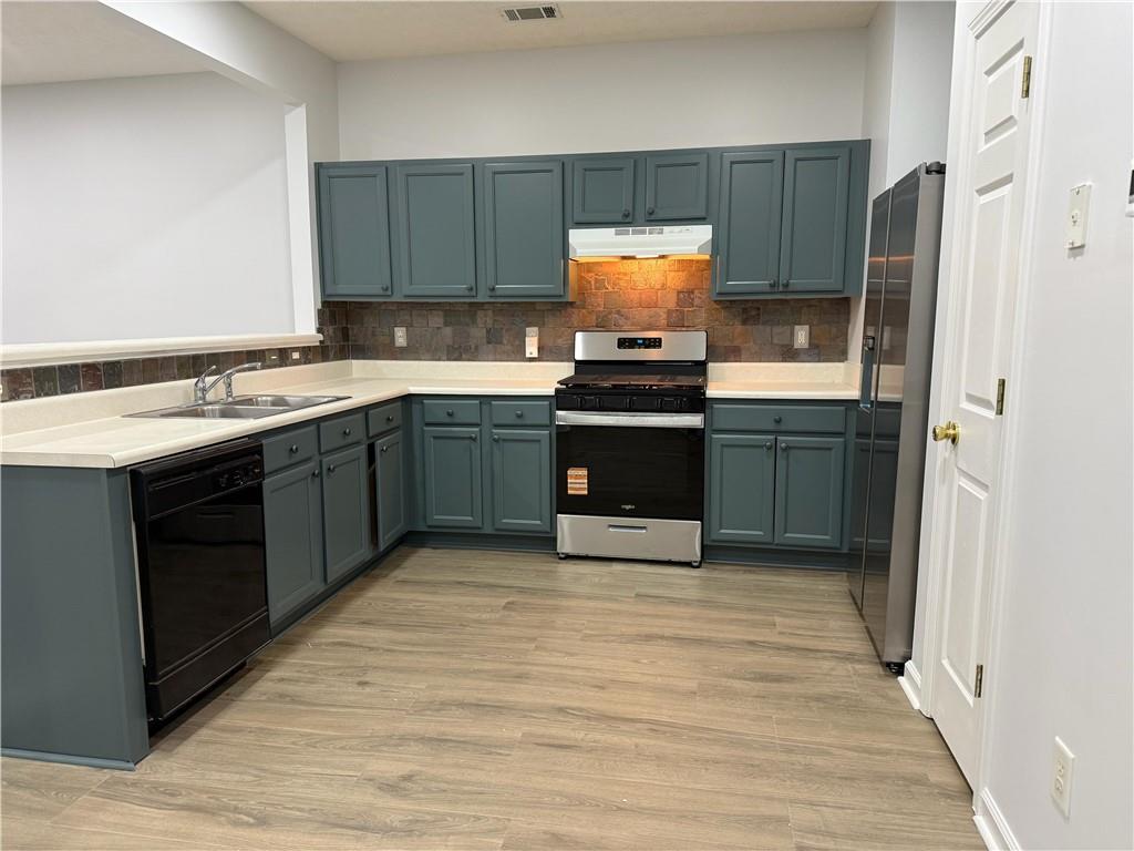 a kitchen with stainless steel appliances granite countertop a stove a sink and a refrigerator