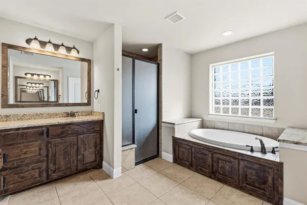 a spacious bathroom with a double vanity sink large mirror and a bathtub